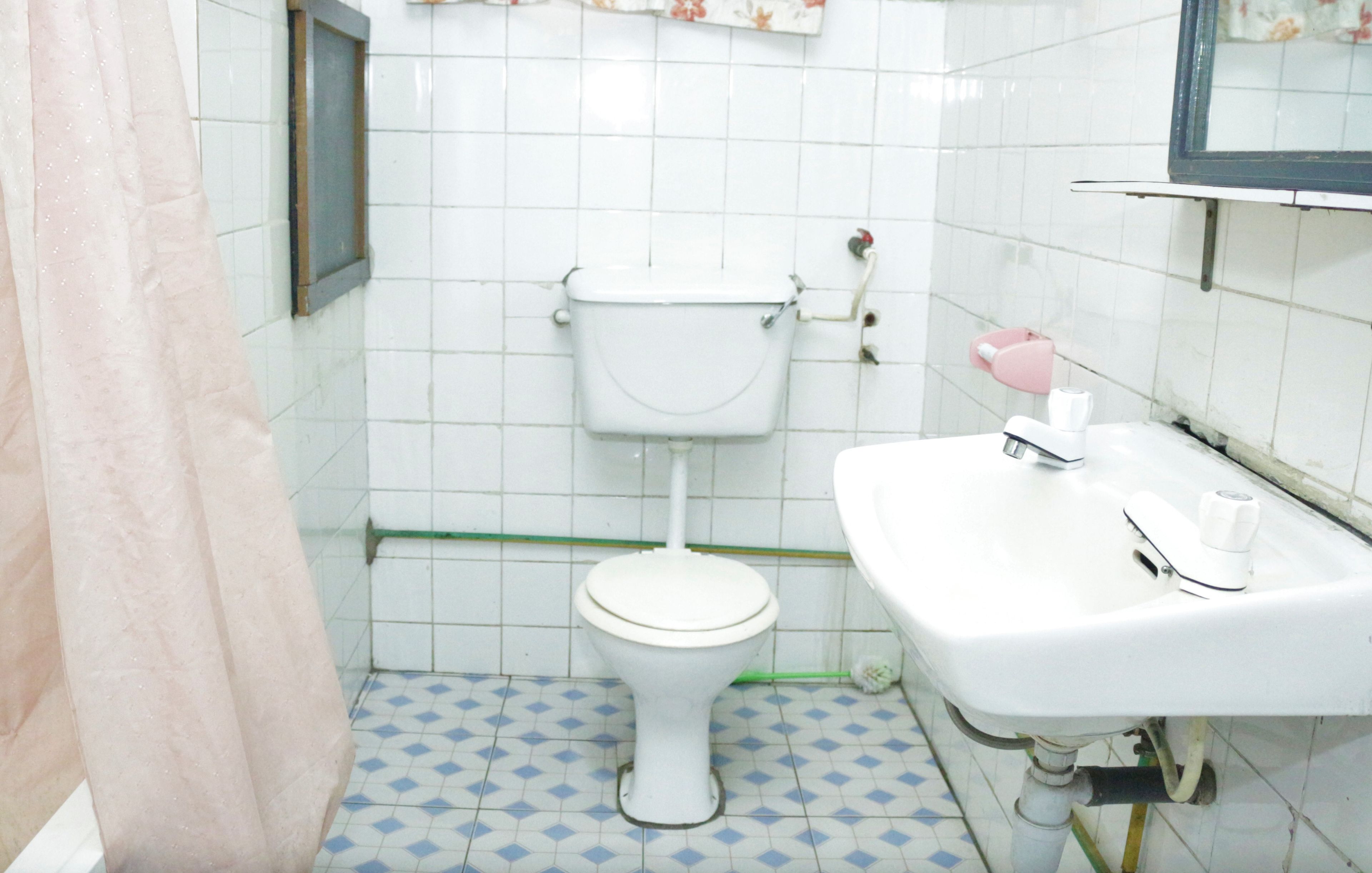 A bathroom with a toilet, sink, and tiled floor.