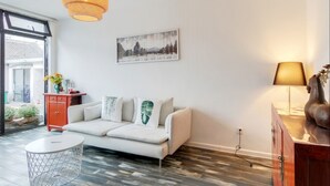 Un salon moderne avec un canapé blanc, une table basse ronde et un plancher en bois.