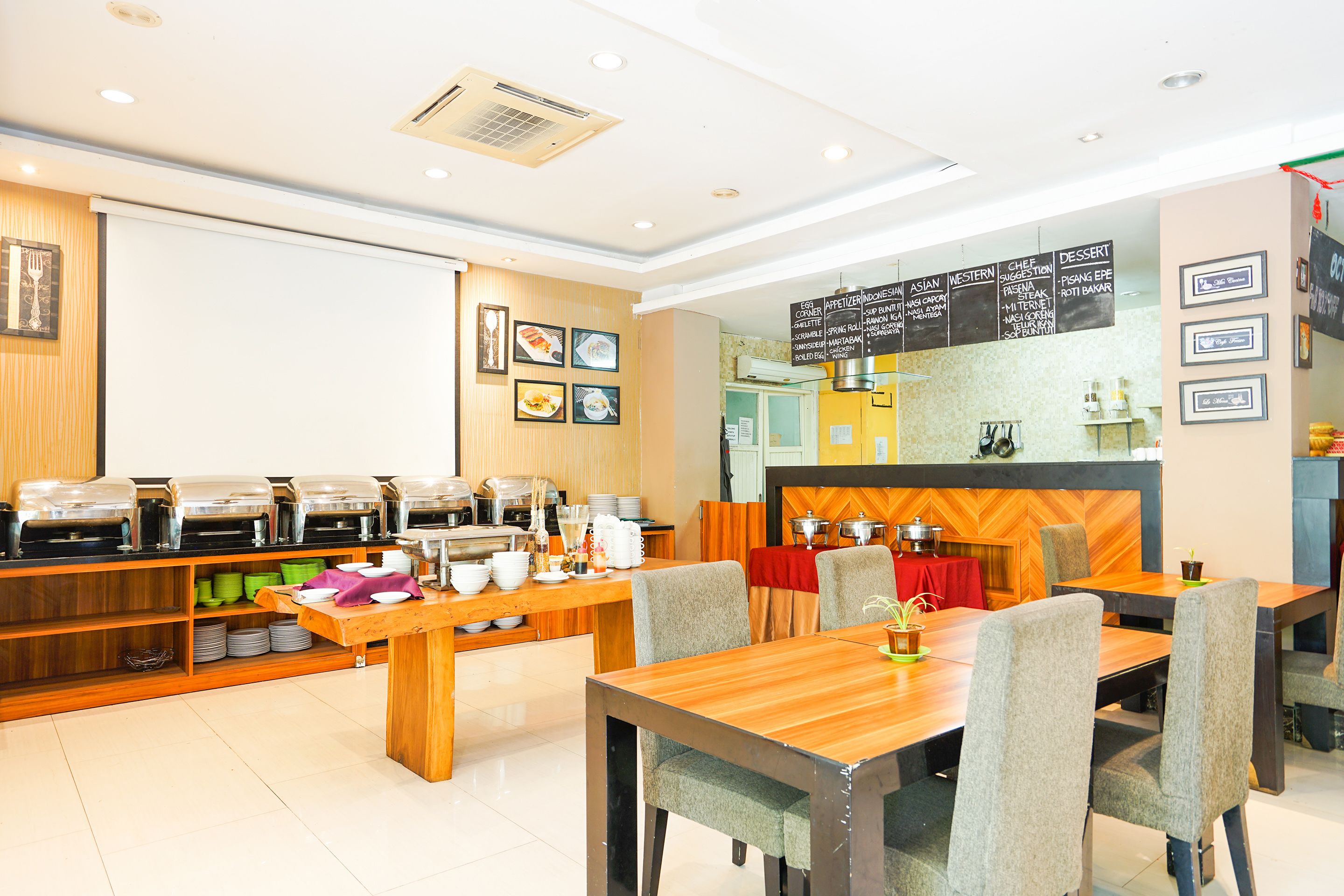 Ein modernes Restaurant mit einem Buffet, Holztischen und verschiedenen Gerichten, die an den Wänden ausgestellt sind.
