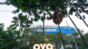 A building with a blue facade and the letters "OYO" prominently displayed in the foreground. - Prime Royal Boutique Hotel (Surabaya)