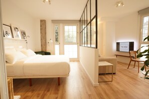 A modern bedroom with a large bed, a desk, and a TV. - The Stay Las Palmas (Las Palmas de Gran Canaria)