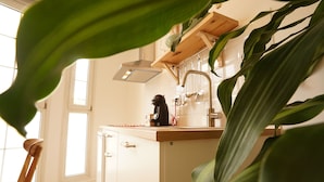 A kitchen with a wooden countertop, a coffee machine, and a hanging pot rack. - The Stay Las Palmas (Las Palmas de Gran Canaria)