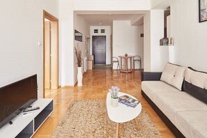 Departamento Deluxe, 1 cama King size y sofá cama, vista a la ciudad | Área de sala de estar | Televisión LCD de 40 pulgadas con canales por cable y televisión 