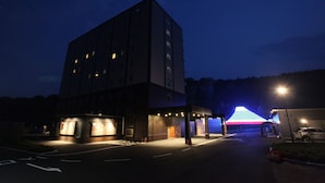 Un edificio moderno con fachada plana, múltiples ventanas y un área de entrada bien iluminada.