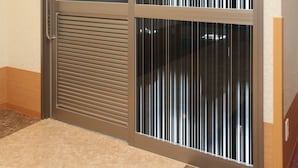 Puerta de sala de fumadores con un letrero, una puerta corredera de vidrio y un picaporte de metal.
