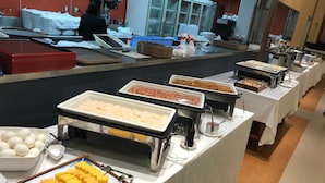 Una mesa de buffet con diversos alimentos y utensilios.
