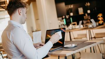 Une personne utilisant un ordinateur portable à une table dans un café.