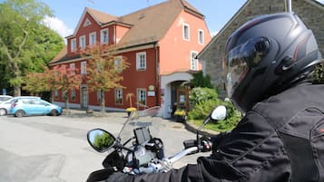 A motorcycle parked in front of a red building with a stone facade.