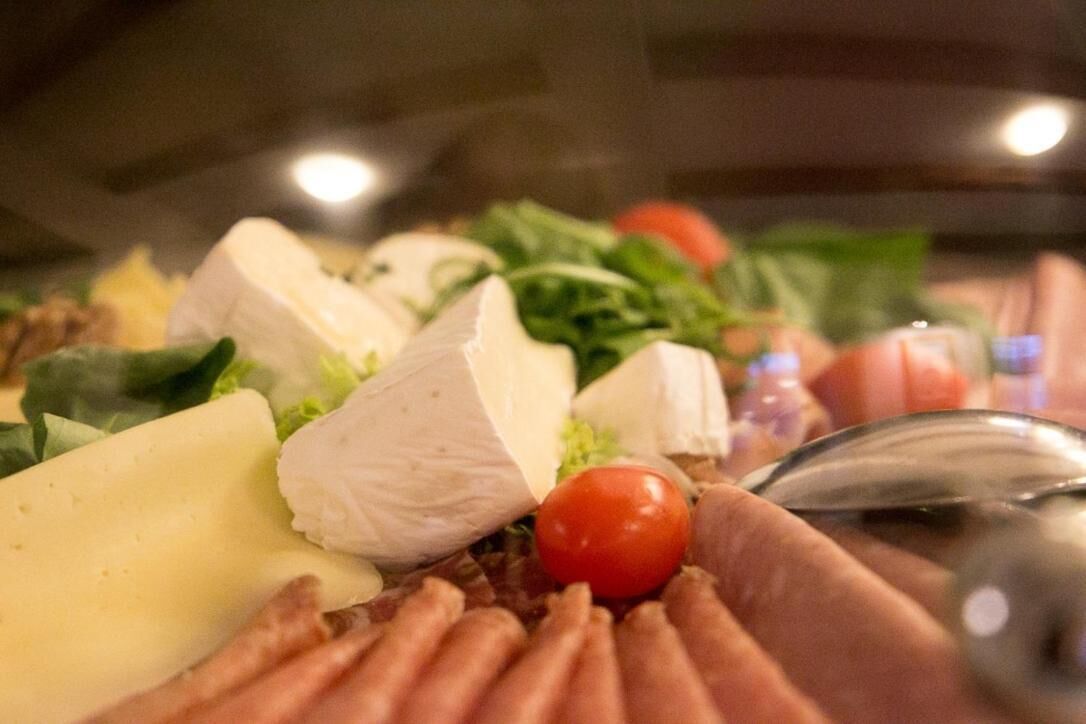 Eine Nahaufnahme einer Speisenauswahl mit Käse, Fleisch und Gemüse.