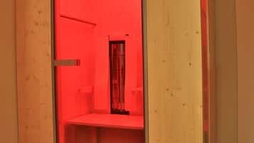 Een kamer met een houten kaststructuur, rode verlichting en een zichtbare deur.