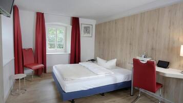 Una habitación de hotel moderna con cama, escritorio, silla y ventana.