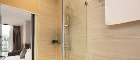 A modern bathroom with a glass shower enclosure, a large mirror, and a towel rack.