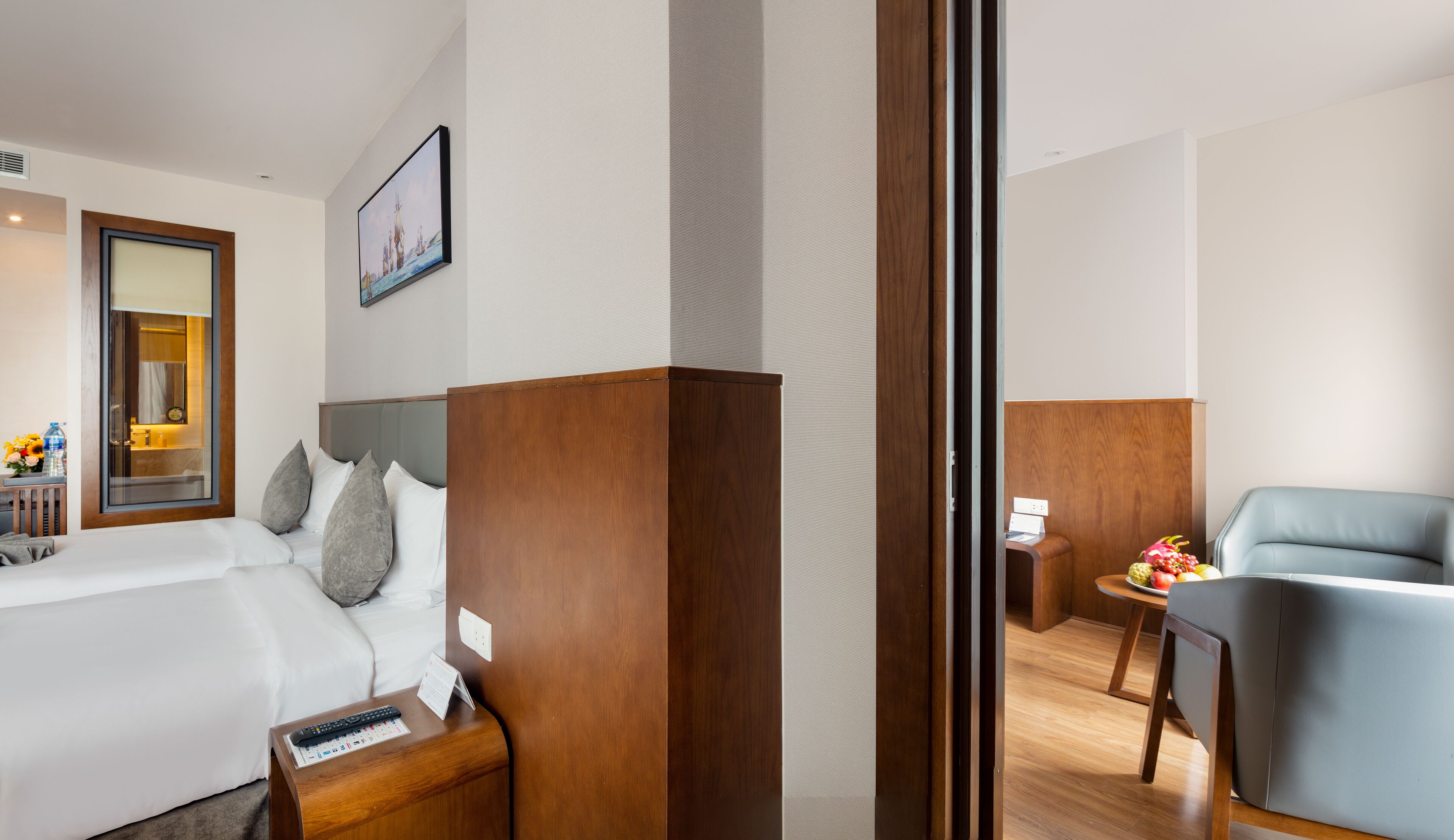 A hotel room with a bed, bedside table, and a desk with a chair.
