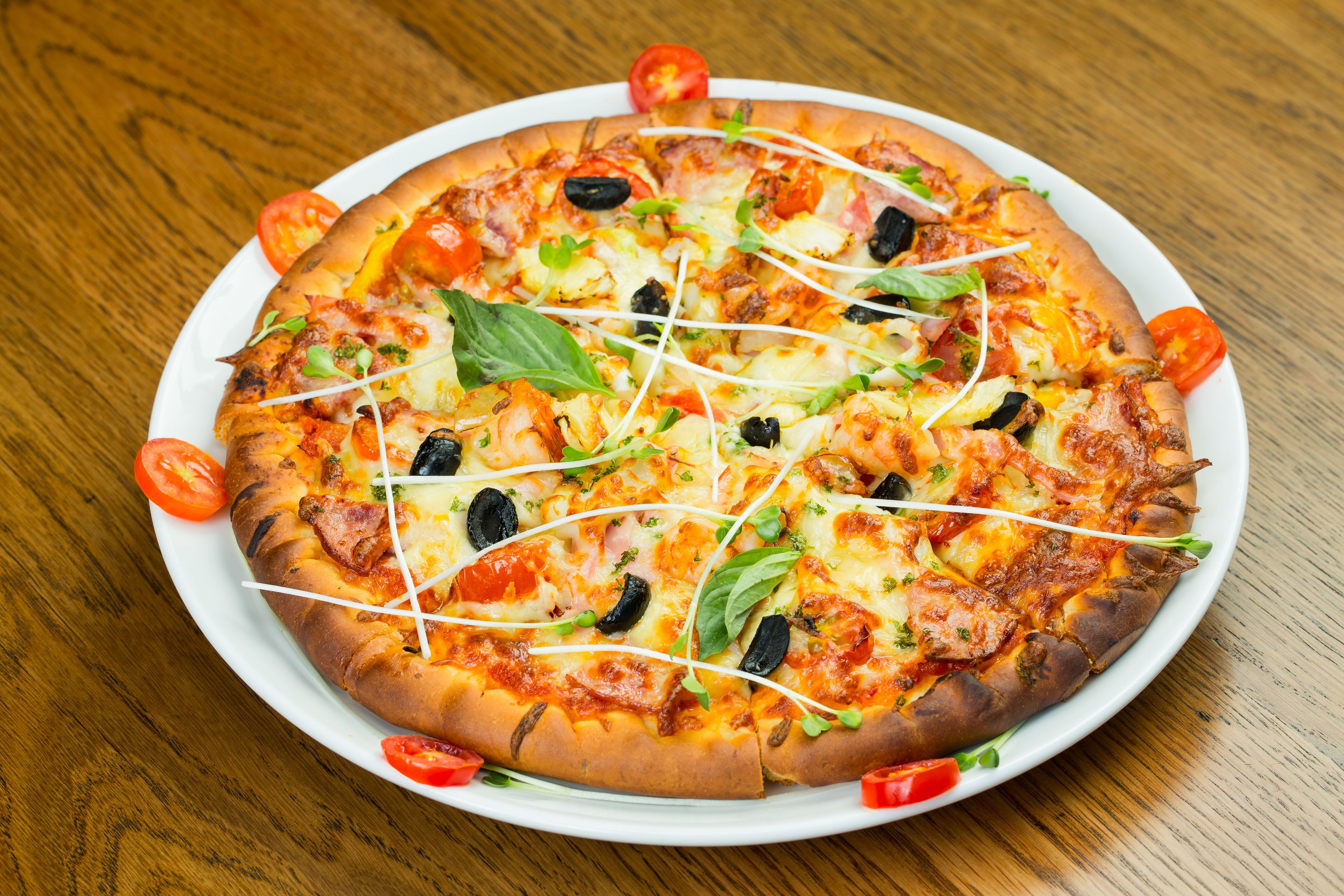 A pizza with various toppings on a white plate.