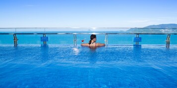 Una piscina al aire libre, sillones reclinables de piscina