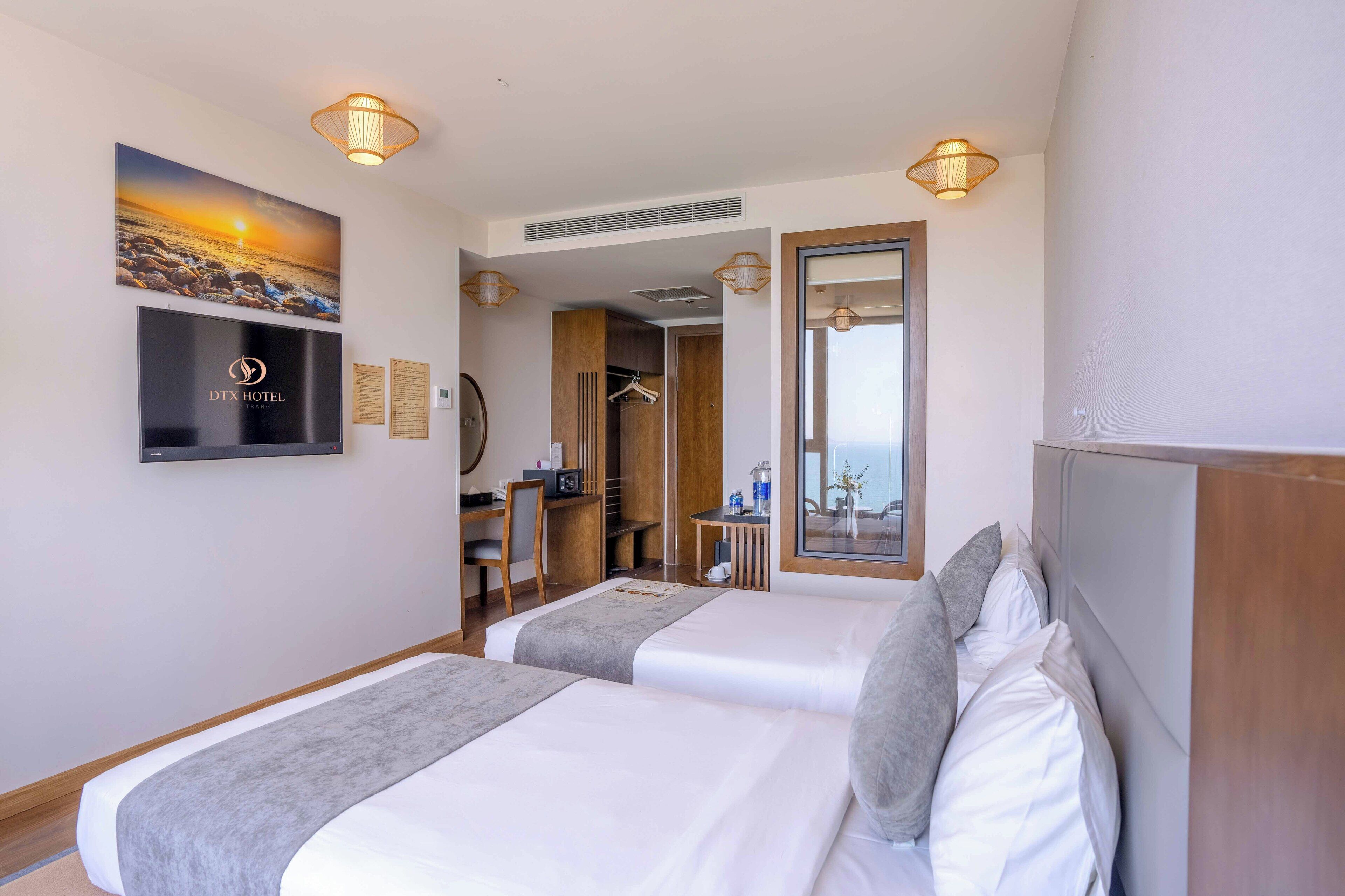 Une chambre d’hôtel avec deux lits, une télévision, un bureau et une armoire.