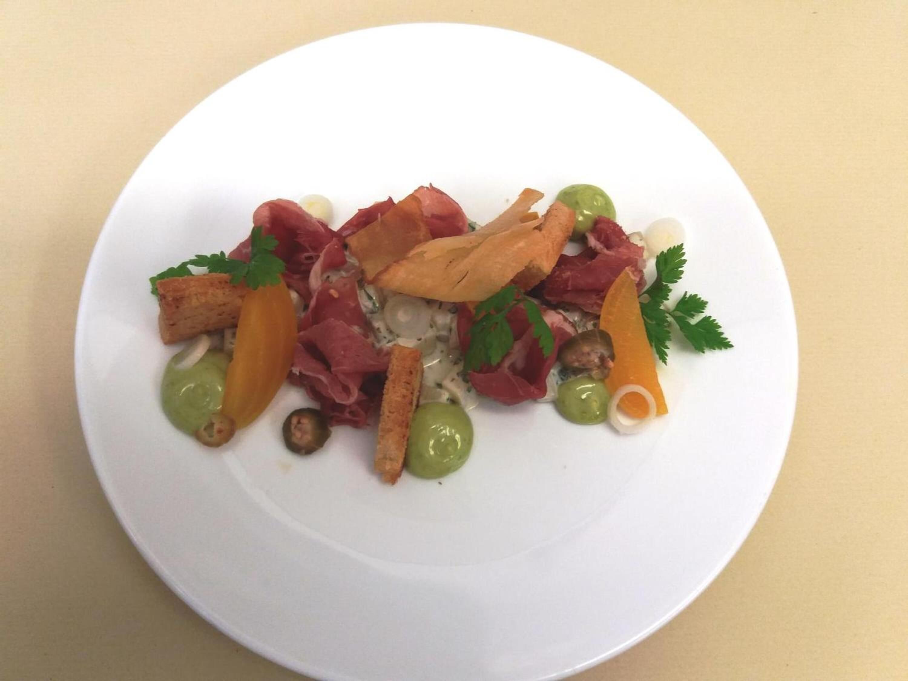 A white plate with a salad containing various ingredients.