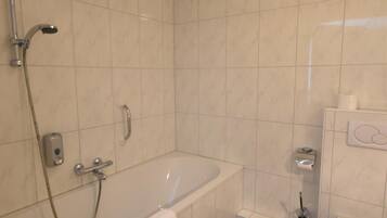 Un baño con bañera, inodoro y ducha.