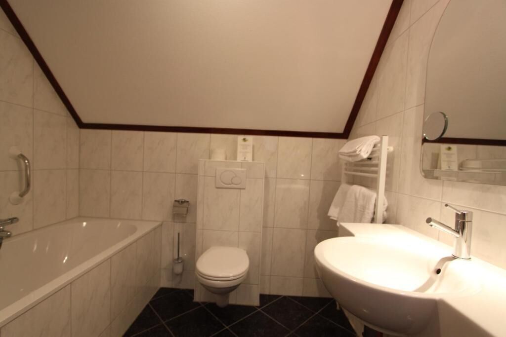 Een badkamer met een bad, toilet en wastafel.