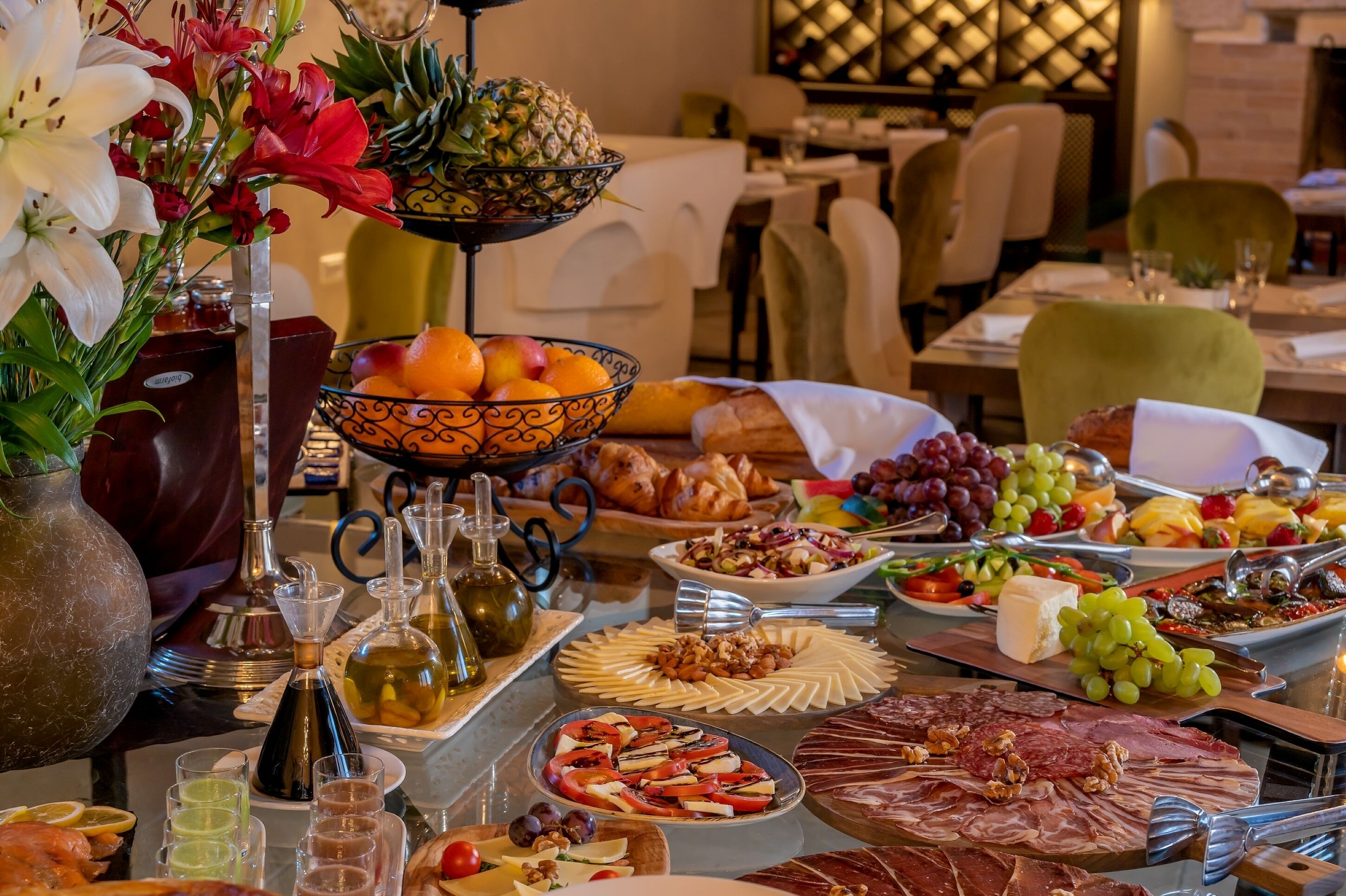 A buffet table with various food items, including fruits, cheeses, and meats.
