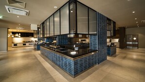 A modern kitchen with a central island, built-in appliances, and a backsplash of blue tiles.