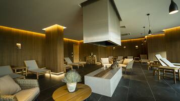 Relax in comfort with lounge chairs and sofas, a bench, and pendant lighting.