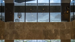 A spacious lobby with a high ceiling, large windows, and a view of an outdoor area. - Wave Resort – Ultra All Inclusive (Pomorie)