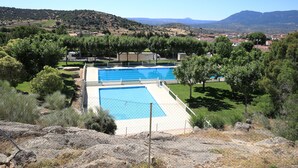 A swimming pool surrounded by trees and a mountainous landscape. - Casas Rurales Abuela Benita (Cebreros)