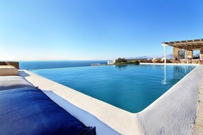 Una piscina al aire libre de temporada, sillones reclinables de piscina