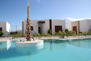 Alberca al aire libre y camastros 