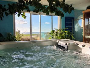 A hot tub with a view of the ocean through large windows. - Fenêtres Sur Mer (Sainte-Marguerite-sur-Mer)