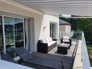 A balcony with a sofa, two chairs, and a table. - Fenêtres Sur Mer (Sainte-Marguerite-sur-Mer)