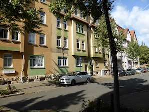 A row of multi-story residential buildings with a paved street in front.