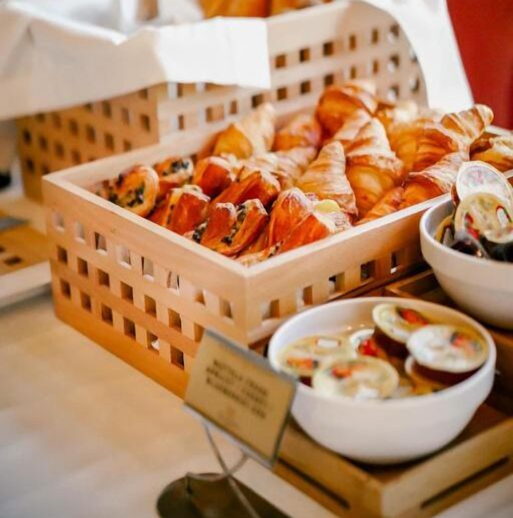 Un buffet con croissant e ciotole di zuppa.