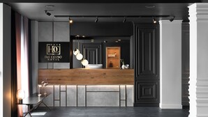 Zona de recepción de hotel con un mostrador de madera, iluminación moderna y un cartel que dice Del Corso Hotel.