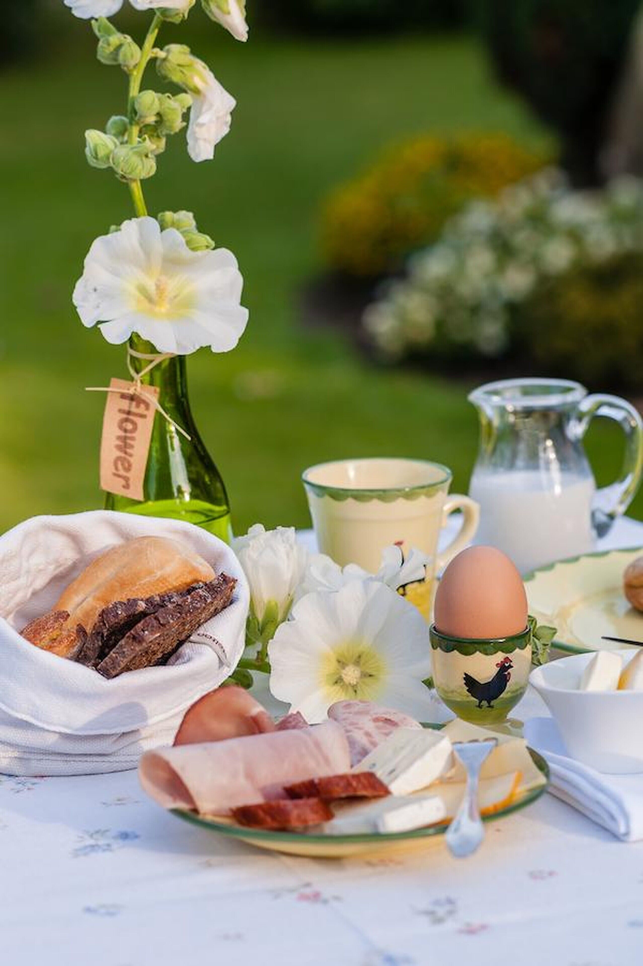 Desayuno con pan, huevos y una botella de leche sobre una mesa.