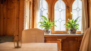 A wooden interior with a window, two potted plants, and a chair. - Gartenheim B&B Tramin (Termeno Sulla Strada del Vino)
