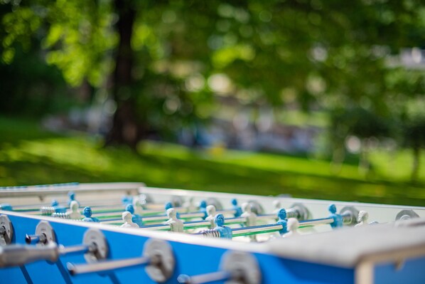 A close-up of a foosball table with a blurred green background. - Gartenheim B&B Tramin (Termeno Sulla Strada del Vino)