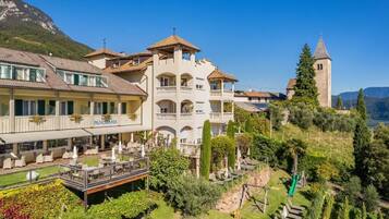 Un hotel con varios balcones, un restaurante llamado 'PANORAMA' y una torre al fondo.