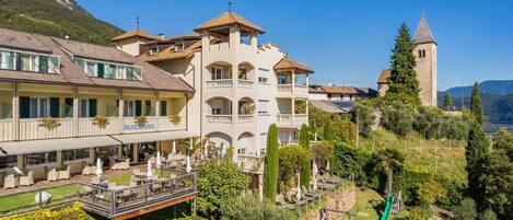Un hotel con varios balcones, un restaurante llamado 'PANORAMA' y una torre al fondo.