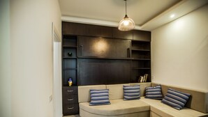 A modern living room with a curved sofa, a remote control, and a pendant light. - Apartment with terrace in Old Tbilisi (Tbilisi)