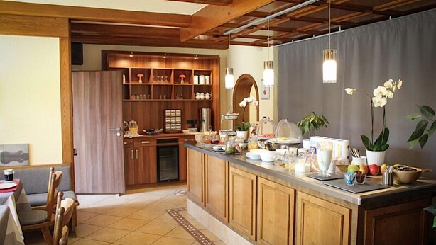 A kitchen with wooden cabinets, a breakfast bar, and various kitchen appliances.
