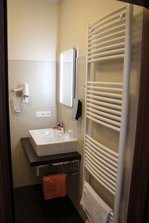 A bathroom with a white sink, a towel rack, and a mirror. - Hotel Rosenhof Garni (Pegnitz)