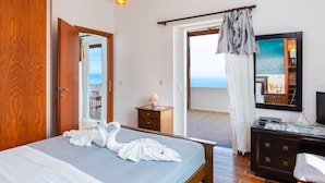 Hotelkamer met een bed, een houten garderobe, een nachtkastje met lamp, een dressoir en een grote spiegel.