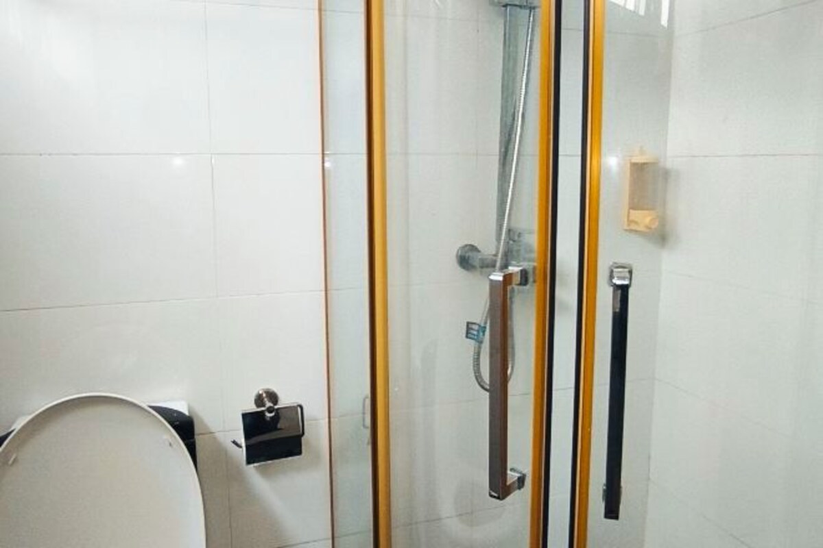 Un bagno con doccia in vetro, un water e un porta asciugamani.