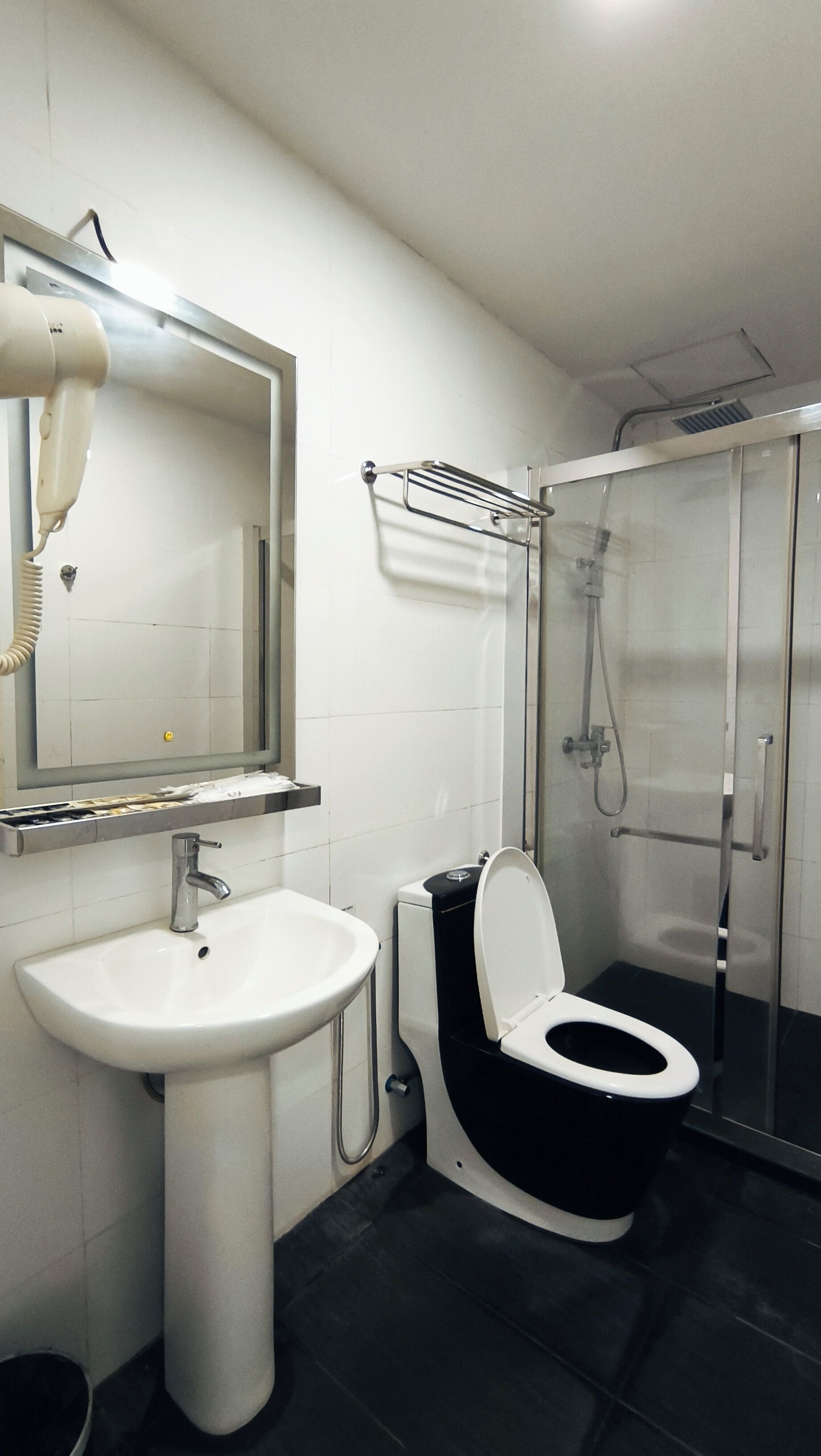 Un baño con lavamanos, inodoro y cabina de ducha de vidrio.