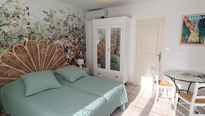 A bedroom with a bed, a wardrobe, a chair, and a table. - Single storey studio, private swimming pool, secure parking (Callian)
