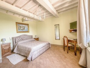 A bedroom with a bed, a desk, a chair, a mirror, a chandelier, and a painting on the wall. - House with private pool & air conditioning at 500 meter from village. Great view (Terni)