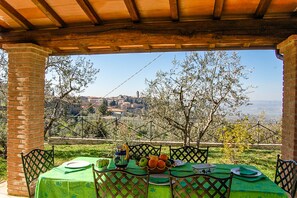 An outdoor dining area with a table set for two, overlooking a scenic view of a town and countryside. - House with private pool & air conditioning at 500 meter from village. Great view (Terni)