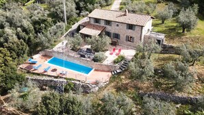 Una casa de piedra con piscina y mobiliario de exterior.
